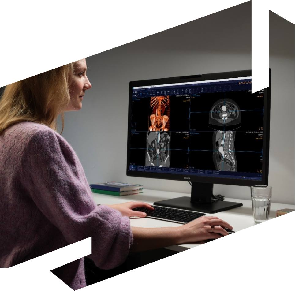 Female professional viewing medical scans on larger computer screen